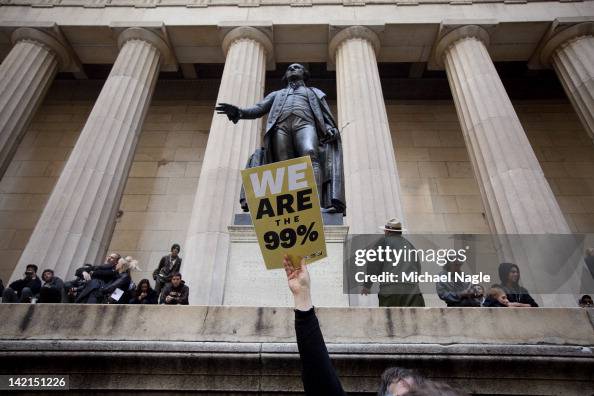 Getty images photo of a protestor holding a placard reading WE ARE THE 99%