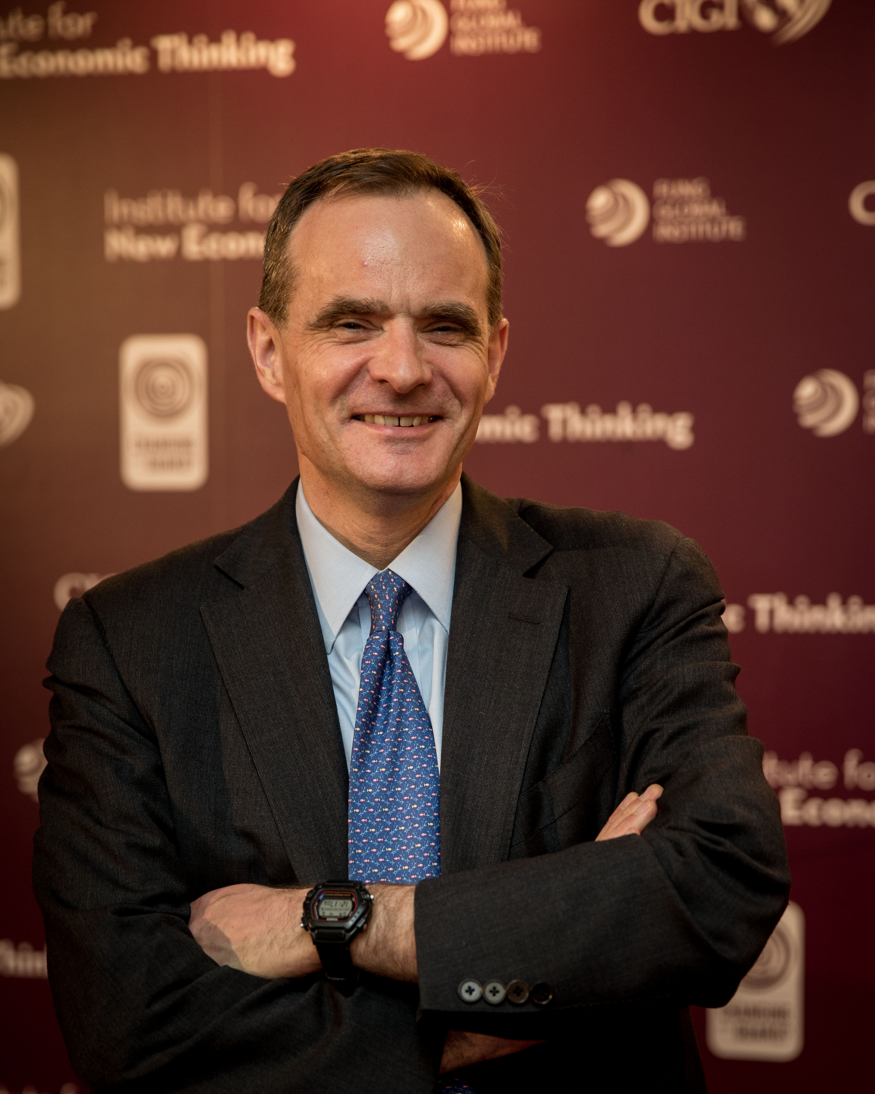 Speaker at Changing of the Guard conference in front of branded step and repeat backdrop